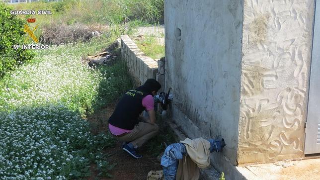 Un agente de la Guardia Civil inspecciona una casa de campo asaltada por los ladrones