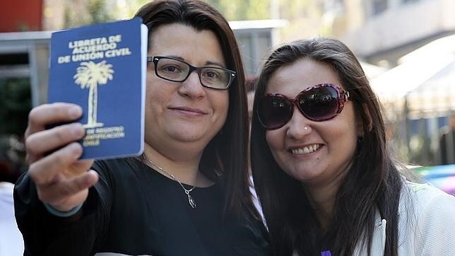 Roxana Ortiz (izquierda) y Virginia Gómez muestran el documento que acredita su unión civil