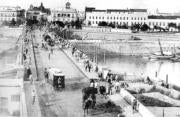 Una estampa de los primeros años del puente, con las farolas gemelas originales, adornado con banderas. ABC
