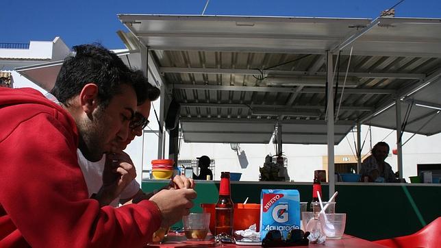 Dos jóvenes saborean caracoles en San Agustín