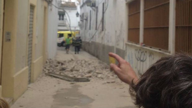 Una persona señala el lugar del derrumbe