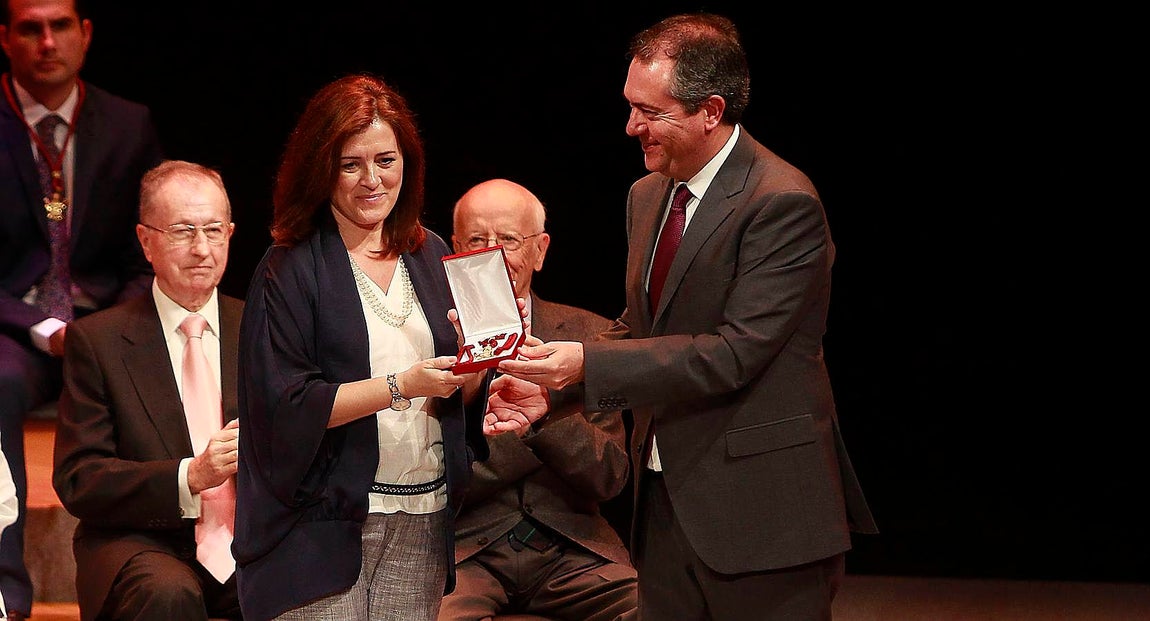 La directora del CEIP Práctica, Consolación Jurado, recoge la medalla concedida a su colegio