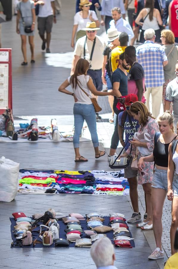 En imágenes, la calle Tetuán de Sevilla invadida por los manteros