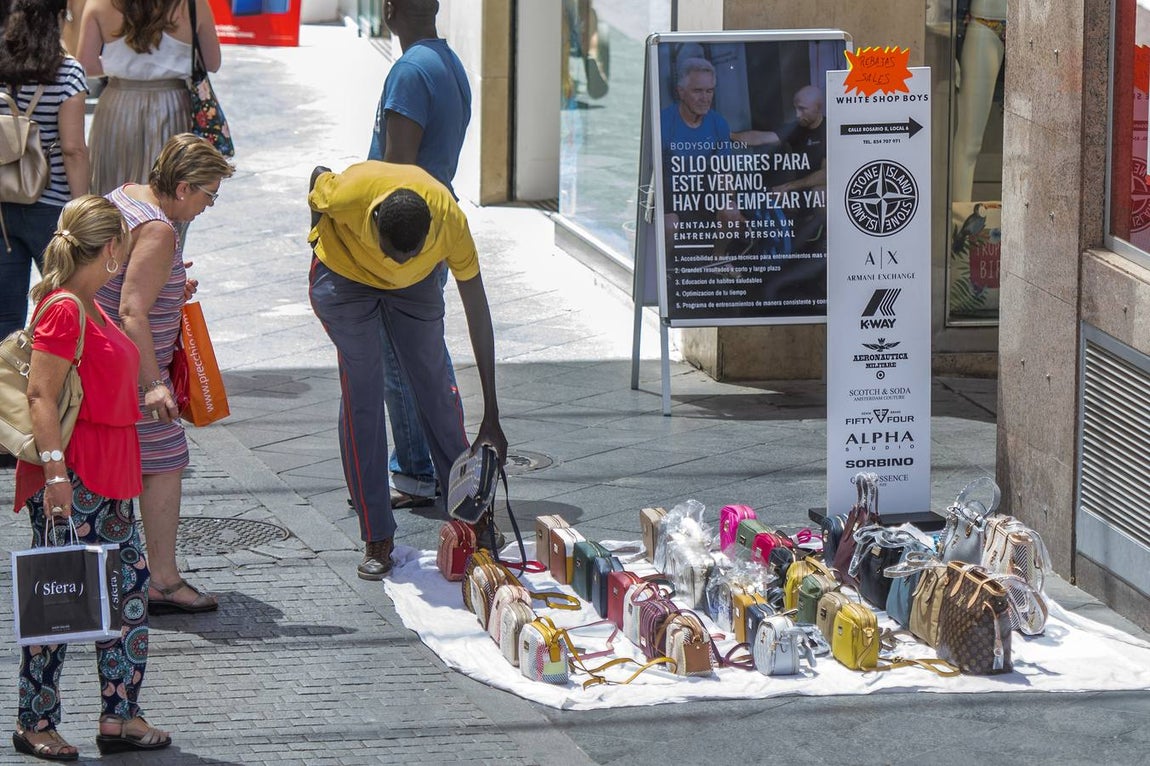 En imágenes, la calle Tetuán de Sevilla invadida por los manteros