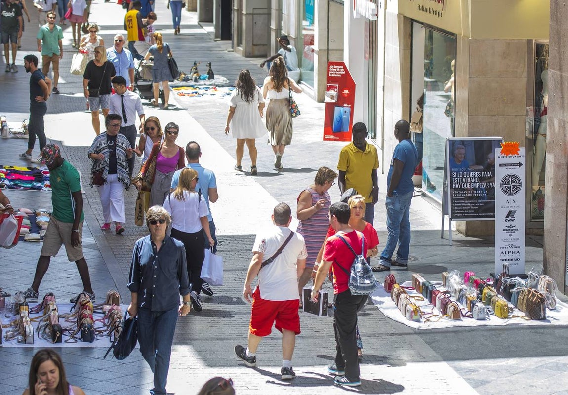 En imágenes, la calle Tetuán de Sevilla invadida por los manteros