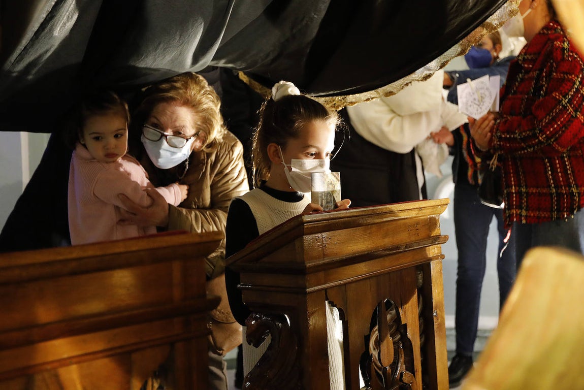 Los niños pasan bajo el manto de la Virgen de los Dolores de Córdoba, en imágenes