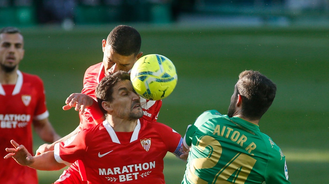 Diego Carlos y Jesús Navas saltan por un balón en presencia de Aitor durante el derbi Betis - Sevilla