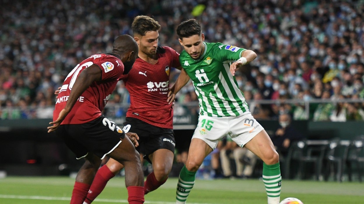 Álex Moreno encara a dos futbolistas del Valencia