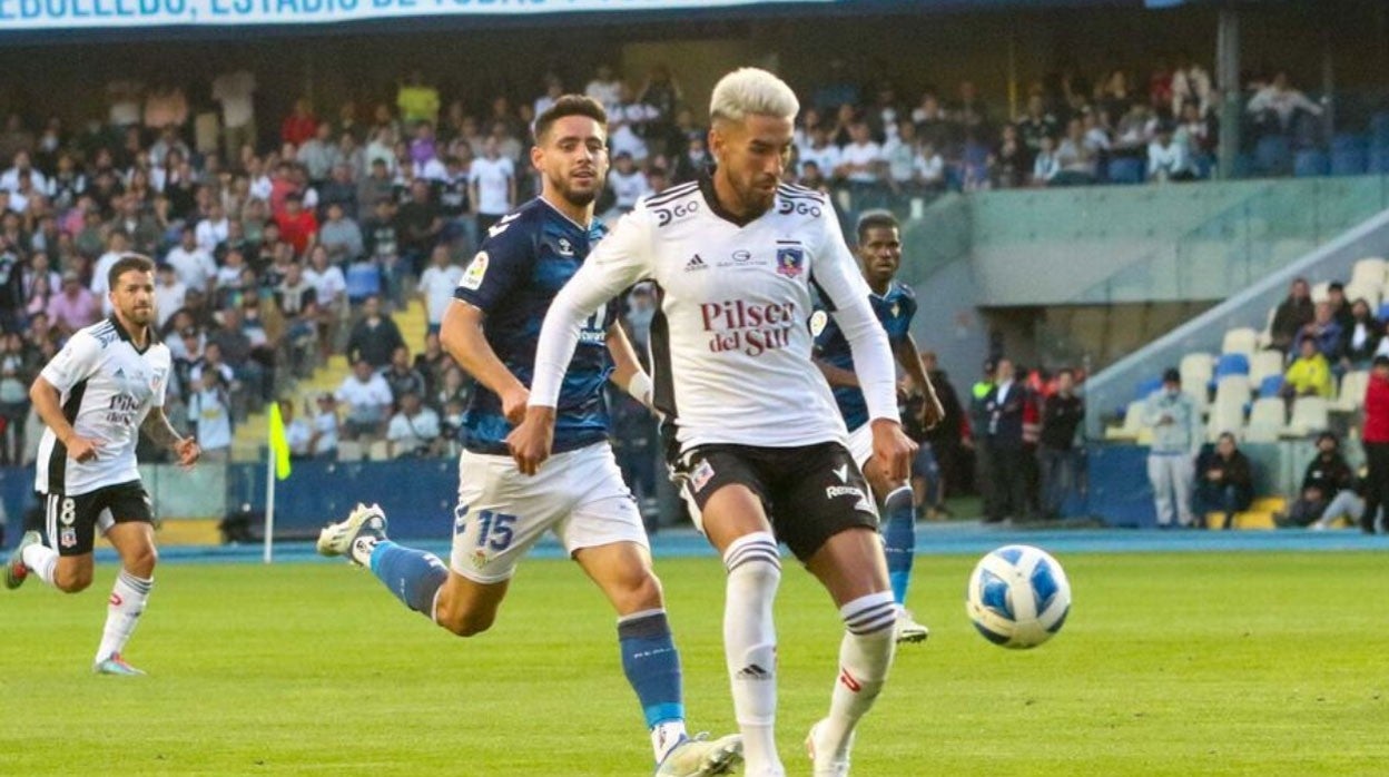 Álex Moreno, tras Lucero, jugador del Colo Colo, en un lance del encuentro jugado en Concepción en la madrugada del jueves