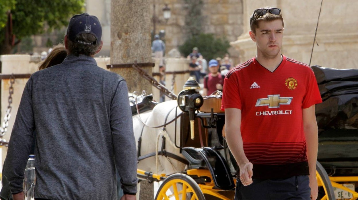 Un seguidor del Manchester United pasea con su camiseta por el entorno de la Catedral