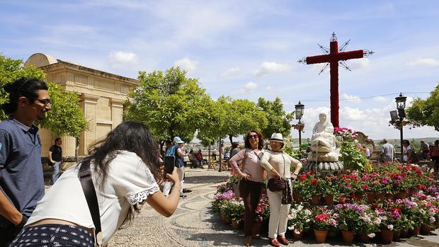 Un grupo de visitantes fotografía la Cruz de Mayo del Triunfo de San Rafael