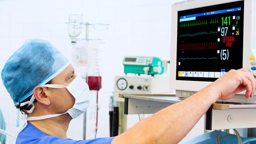 Un profesional sanitario ajusta un aparato de monitorización cardíaca