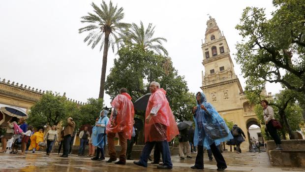 Turistas bajo la lluvia, ayer en el Patio de los Naranjos