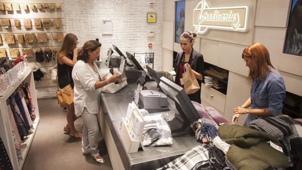 Dependientas de una tienda de ropa atienden a los clientes