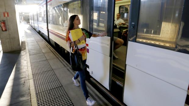 Una chica accede a un vagón del tren que va al Campus de Rabanales