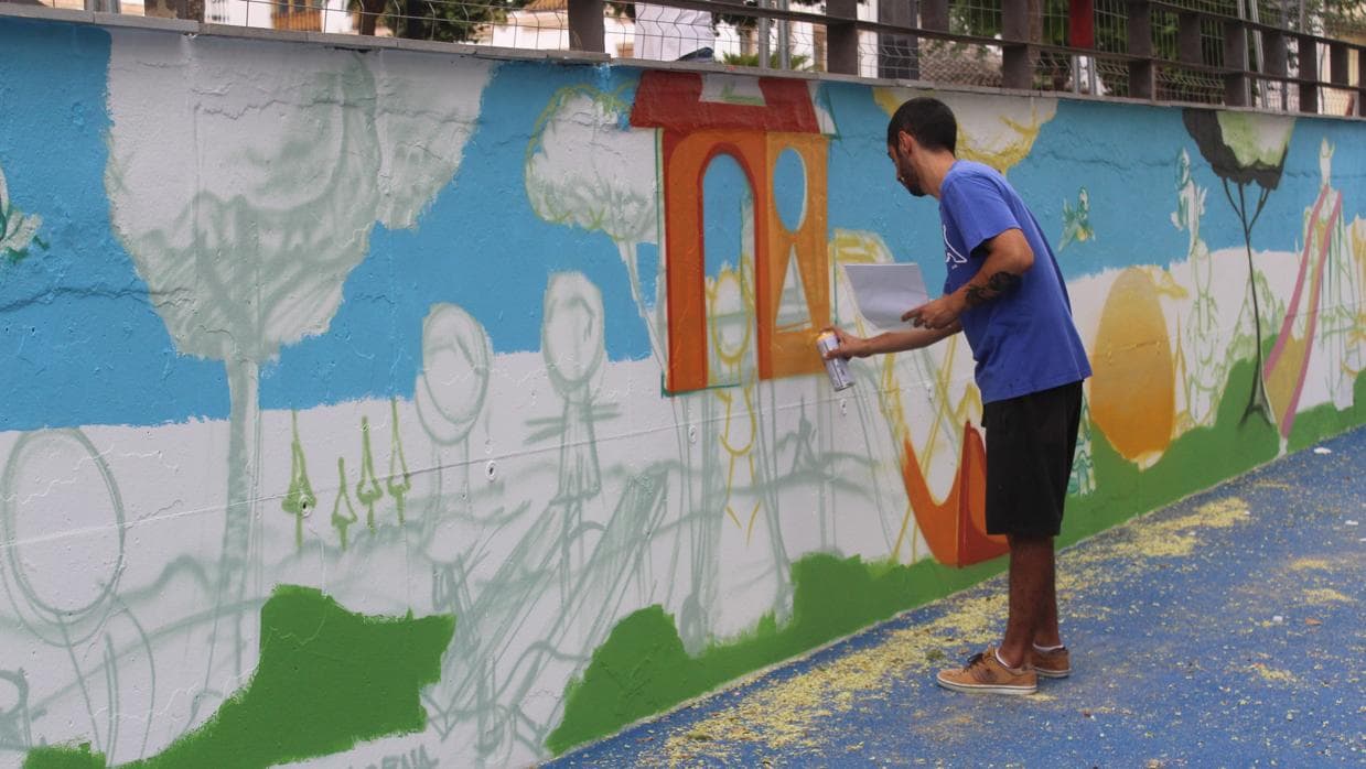 El grafitero empleará una semana en la decoración del muro del recinto infantil.