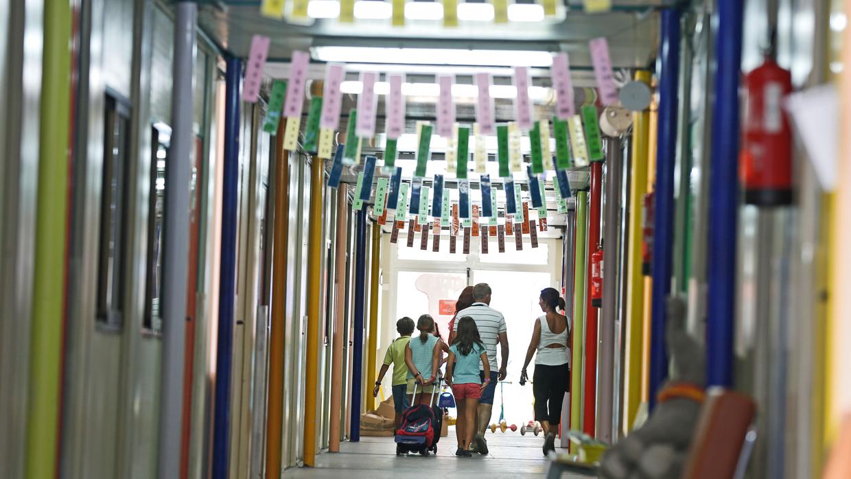 Un grupo de niños camina con sus mochilas por el pasillo de un colegio