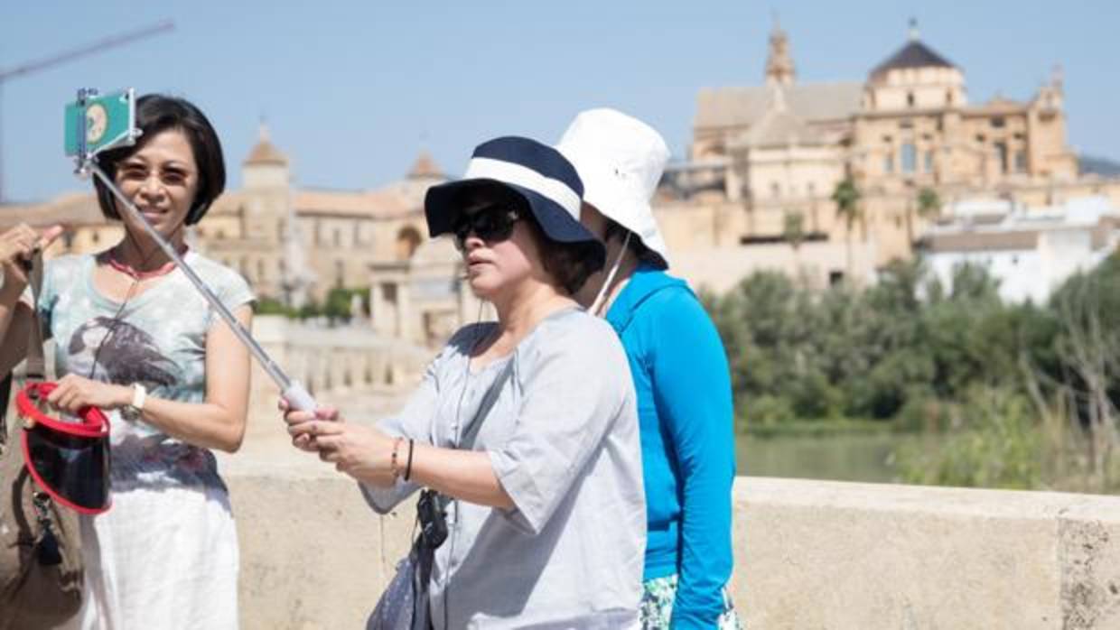 Turistas japonesas se fotografían con la Mezquita-Catedral de fondo