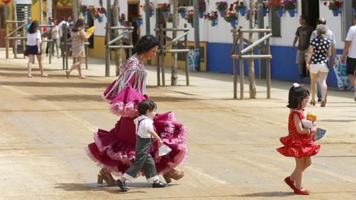 Una mujer cruza una calle con sus hijos