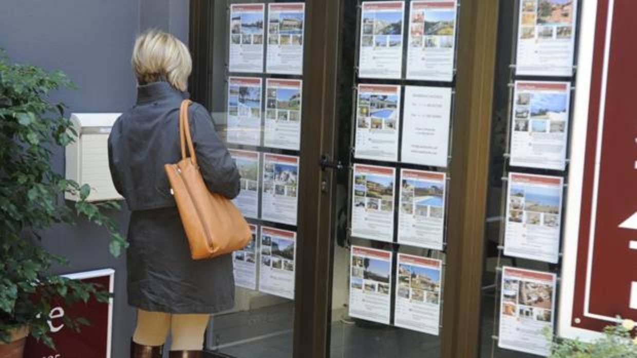 Una mujer mira las viviendas disponibles en una inmobiliaria