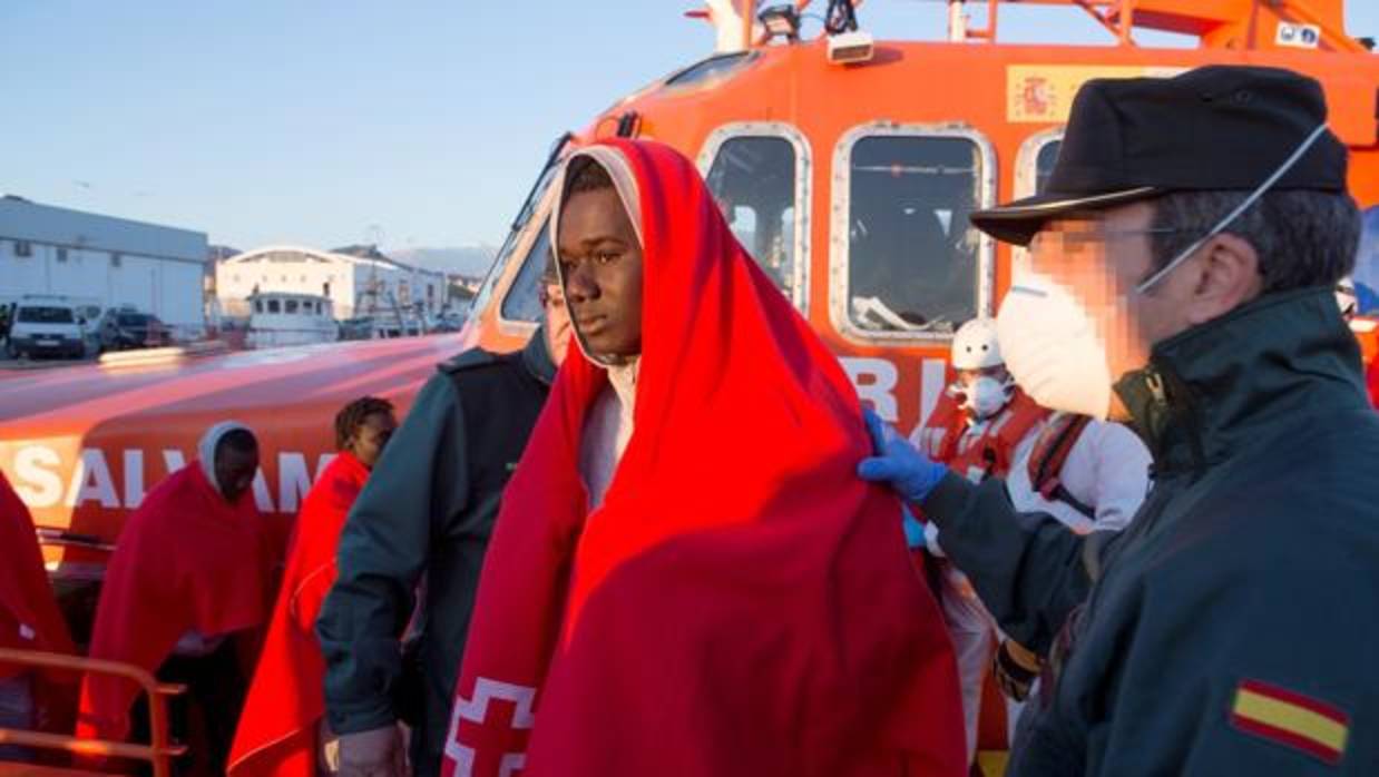 Un Guardia Civil ayuda a un inmigrante en Motril