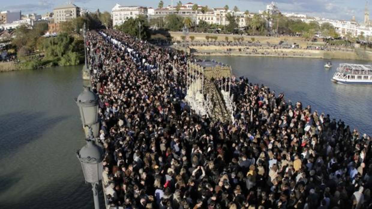 Una procesión en Sevilla a su paso por el puente