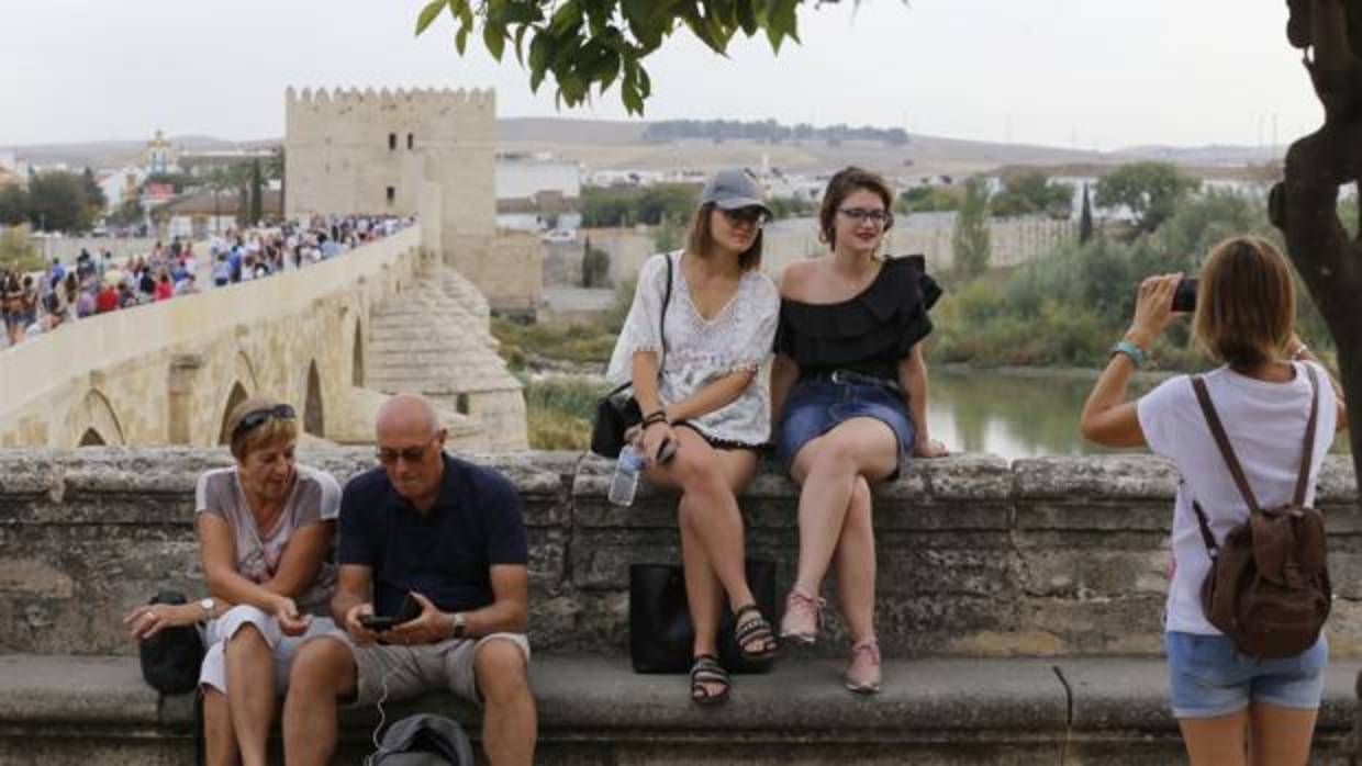 Un grupo de turistas delante del Puente Romano