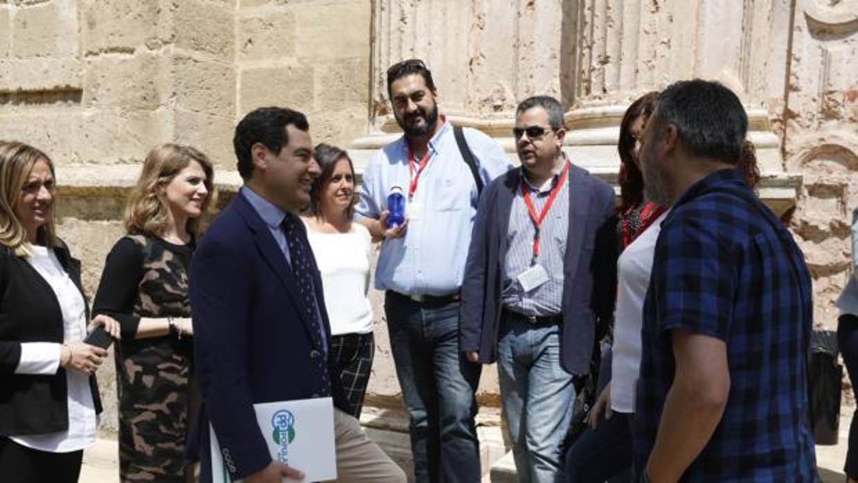 El presidente del PP andaluz, Juanma Moreno, charlando con los profesionales sanitarios en el Parlamento