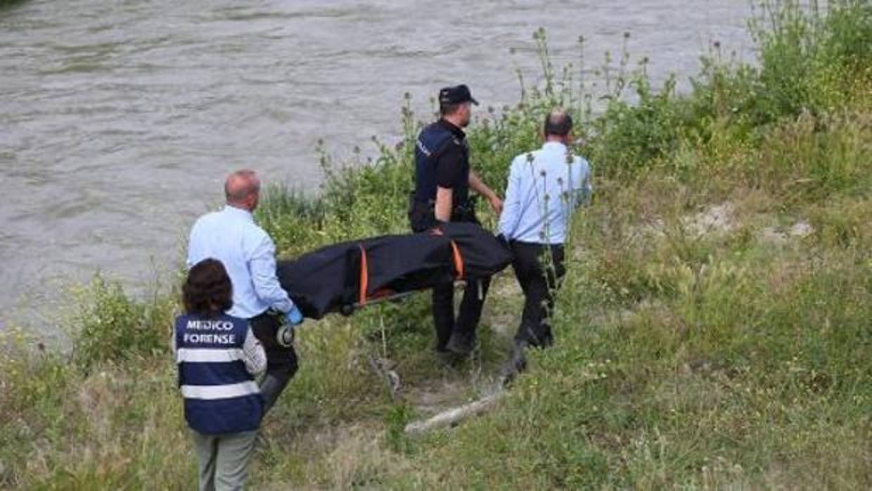 Equipo de forenses trasladando el cuerpo de la víctima junto al río Genil