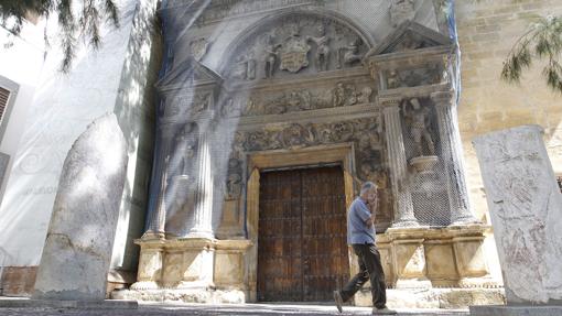Un hombre pasa ante la malla que protege la portada del Arqueológico