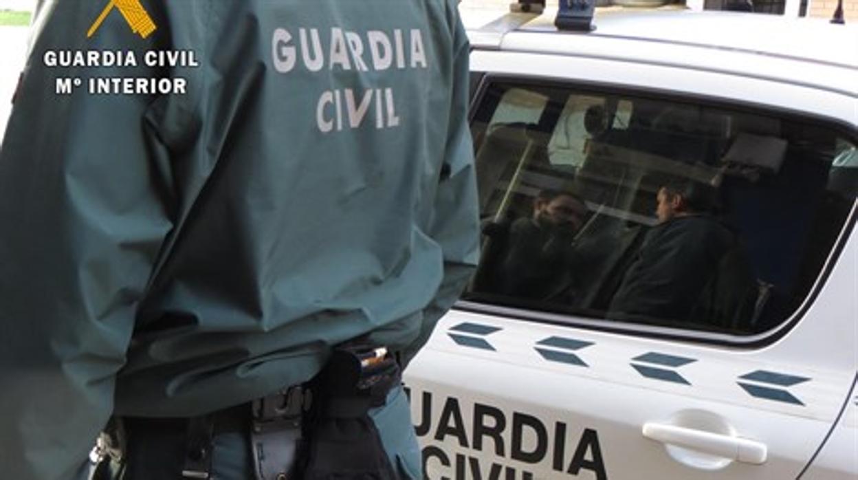 Imagen de agentes de la Guardia Civil junto a un vehículo patrulla.