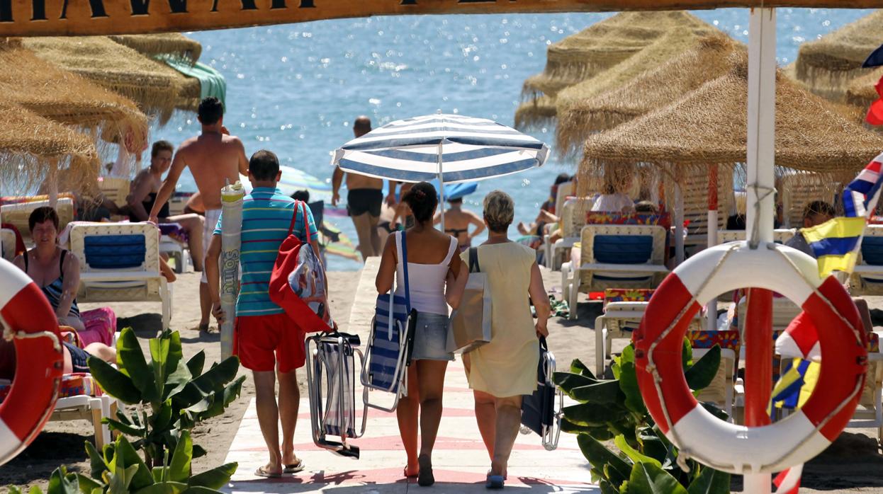 Veraneantes llegando a la playa en Torremolinos