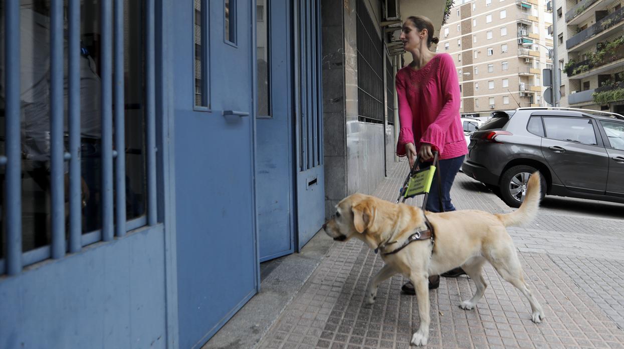 Una joven con su perro a la entrada de un edificio