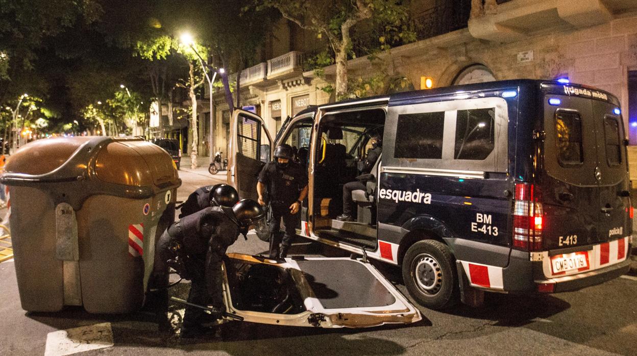 Dos Mossos d'Esquadra recogen la puerta de su furgón durante los altercados del 1 de octubre