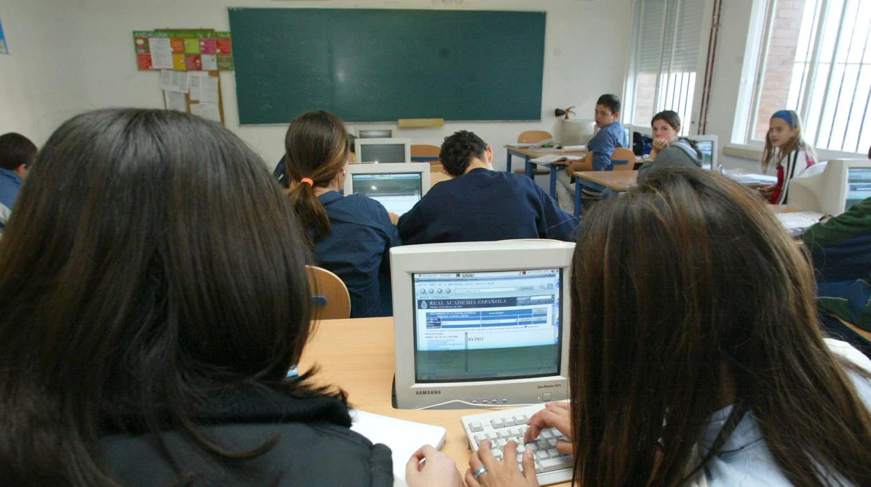 Niños en un aula aprendiendo a usar el ordenador