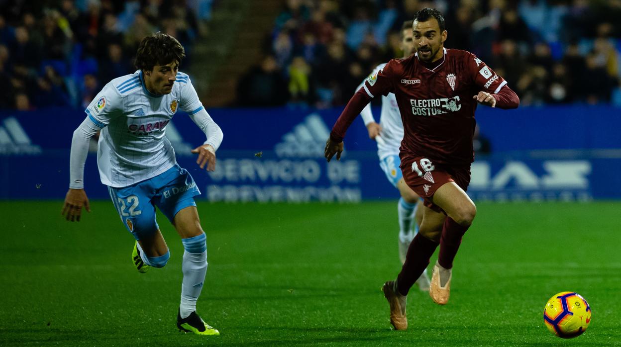 De las Cuevas conduce el balón ante Delmás, en una acción del Zaragoza-Córdoba CF