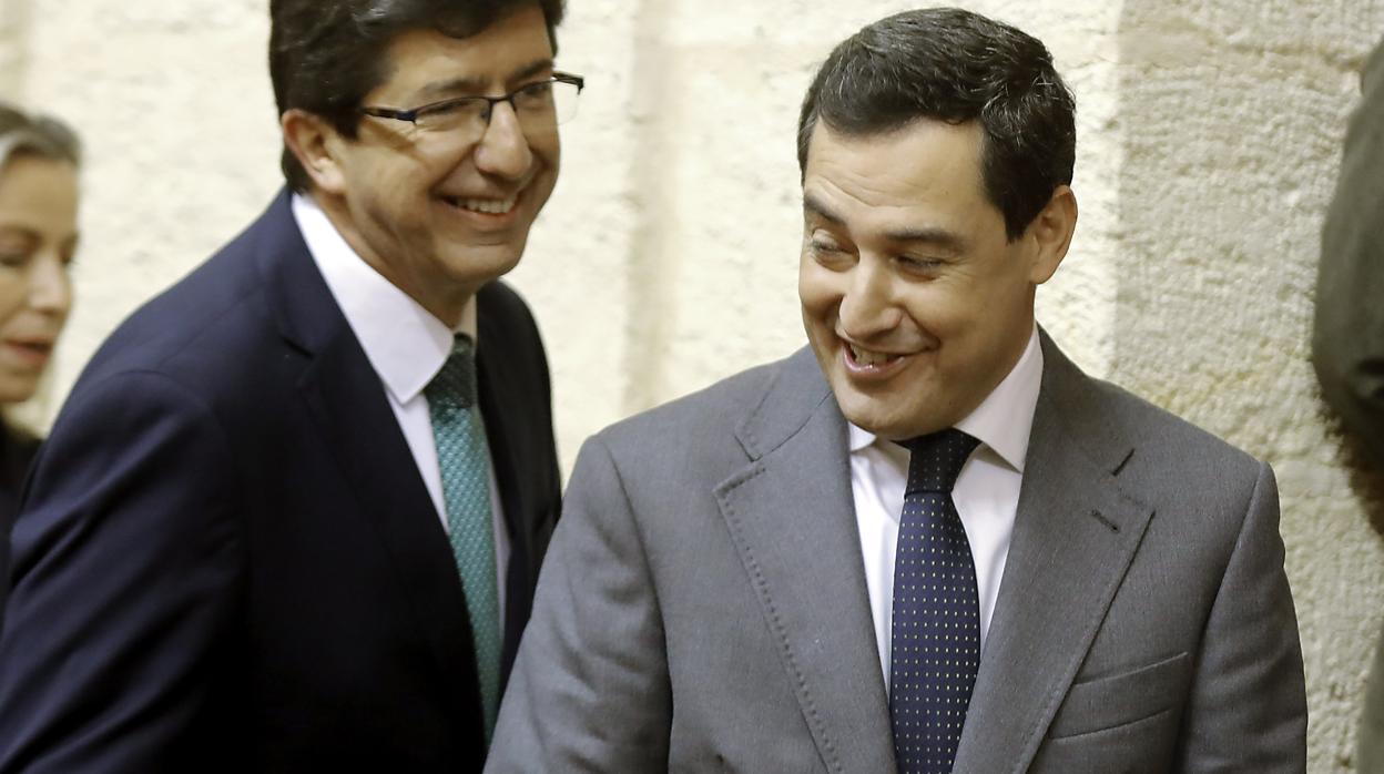 Juan Marín y Juanma Moreno bromean este jueves en el salón de plenos del Parlamento