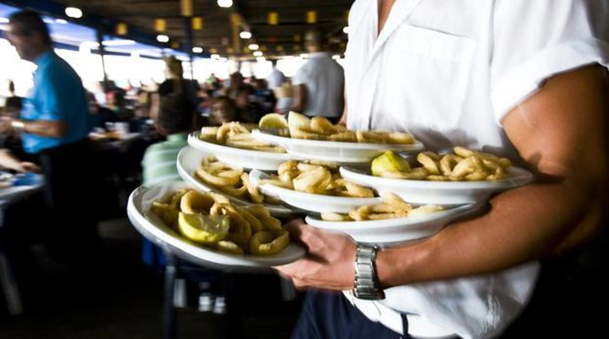 Un camarero llevando platos a una mesa