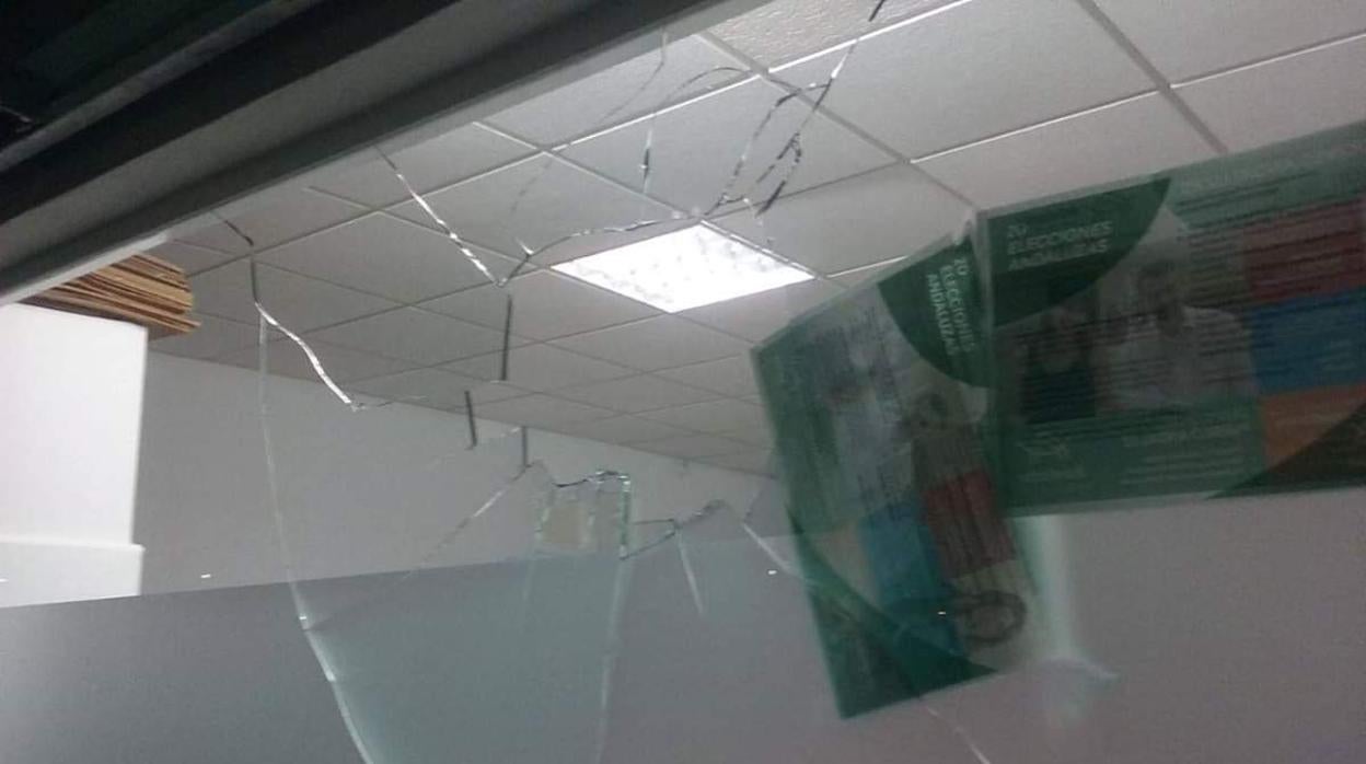 Imagen difundida por IU del cristal de la fachada de la sede de Podemos tras el impacto