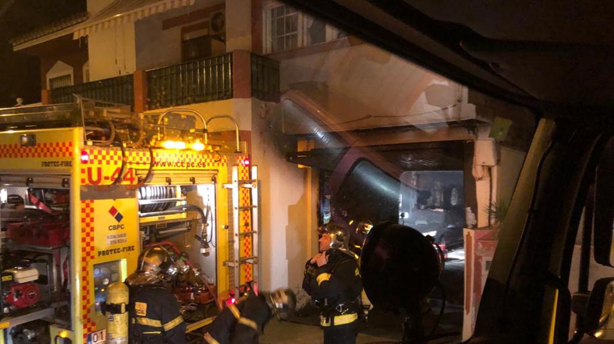 Tres efectivos del Consorcio de Bomberos, ante el garaje donde se ha producido el incendio