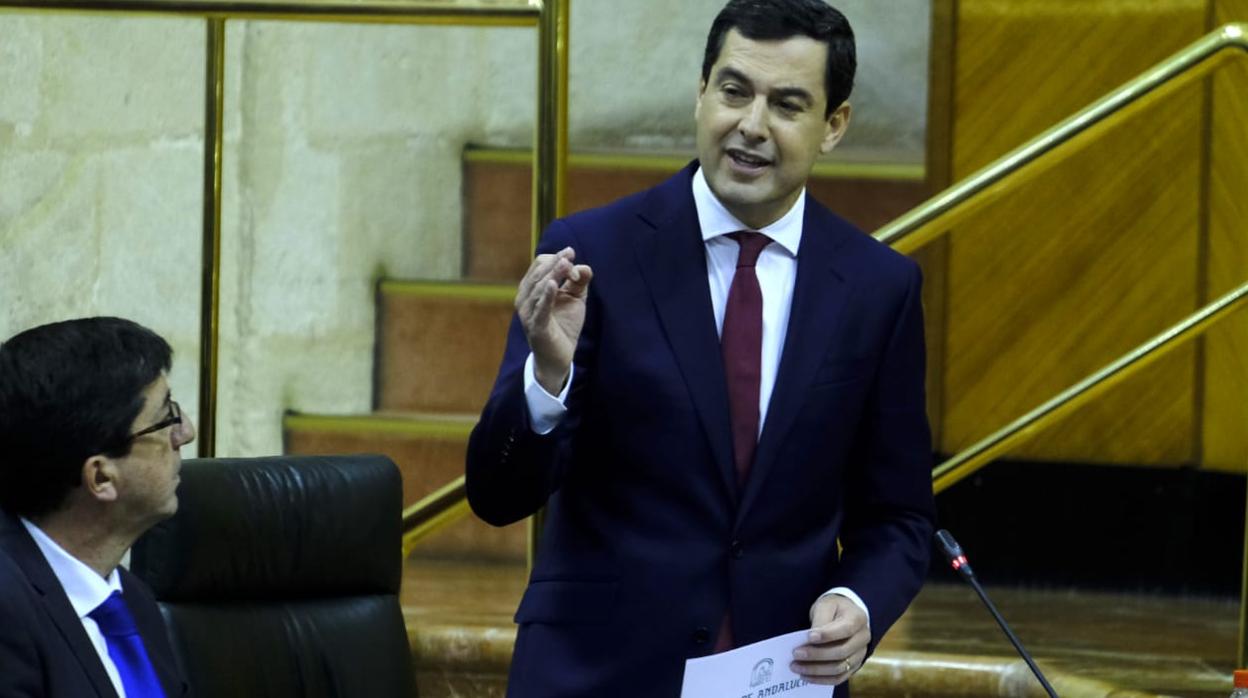 Juanma Moreno interviene ante la mirada de Juan Marín