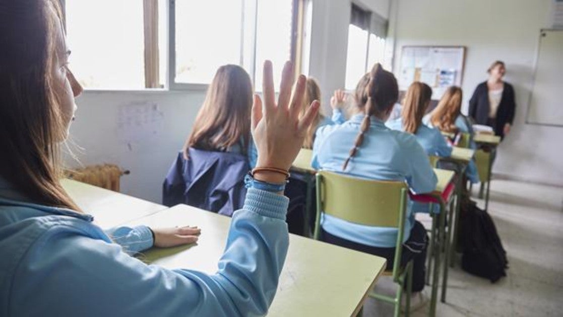 Una alumna levanta la mano en un aula