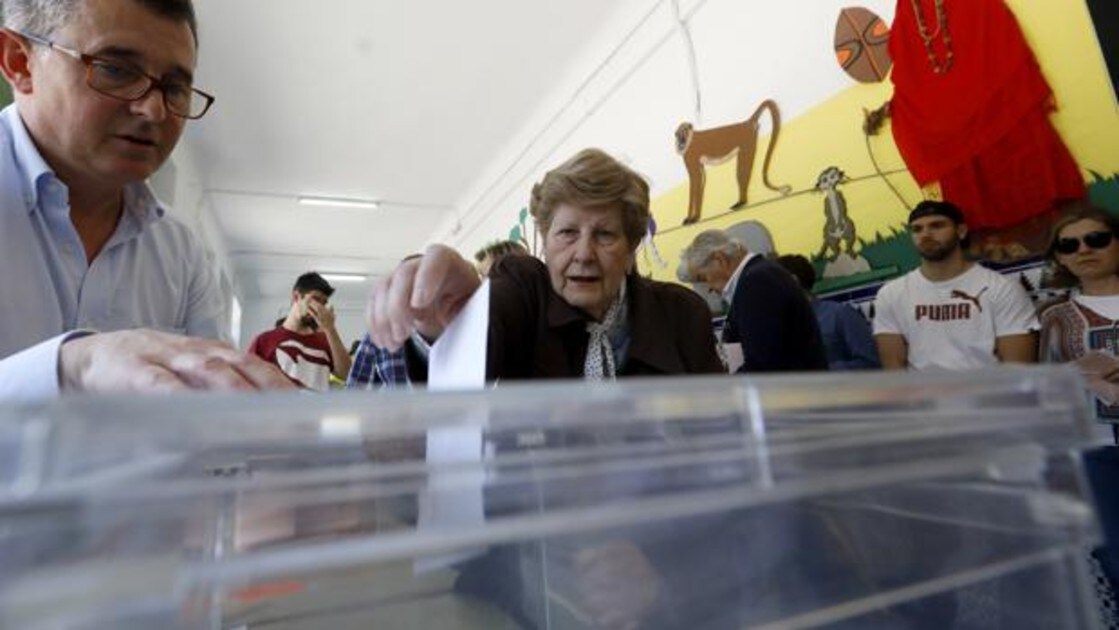 Una mujer introduce su voto en una urna