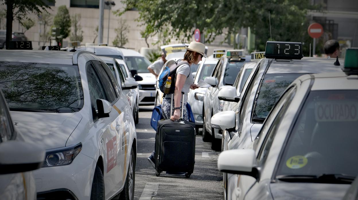 Una clienta bordea los taxis de la estación de Santa Justa, durante una de las huelgas del sector