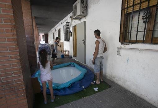 Una familia junto a un local adaptado como vivienda en el barrio de Las Moreras en Córdoba