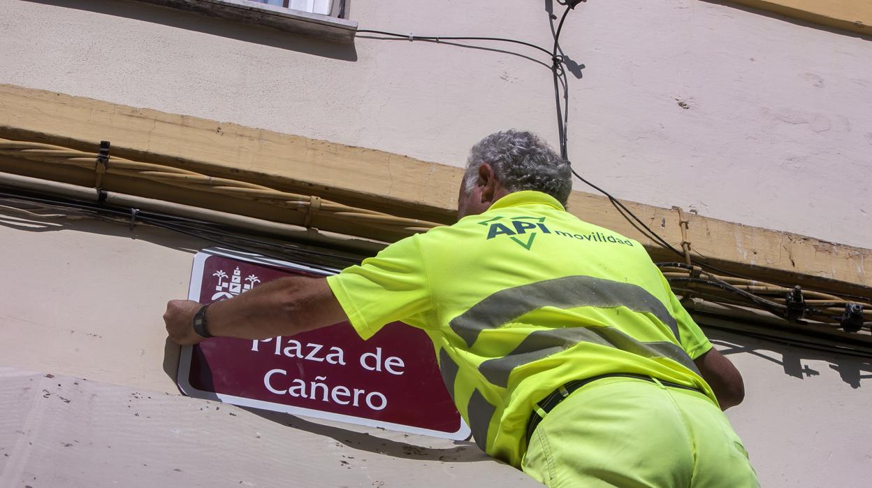 Un operario del Ayuntamiento coloca la placa con el nombre de Plaza de Cañero