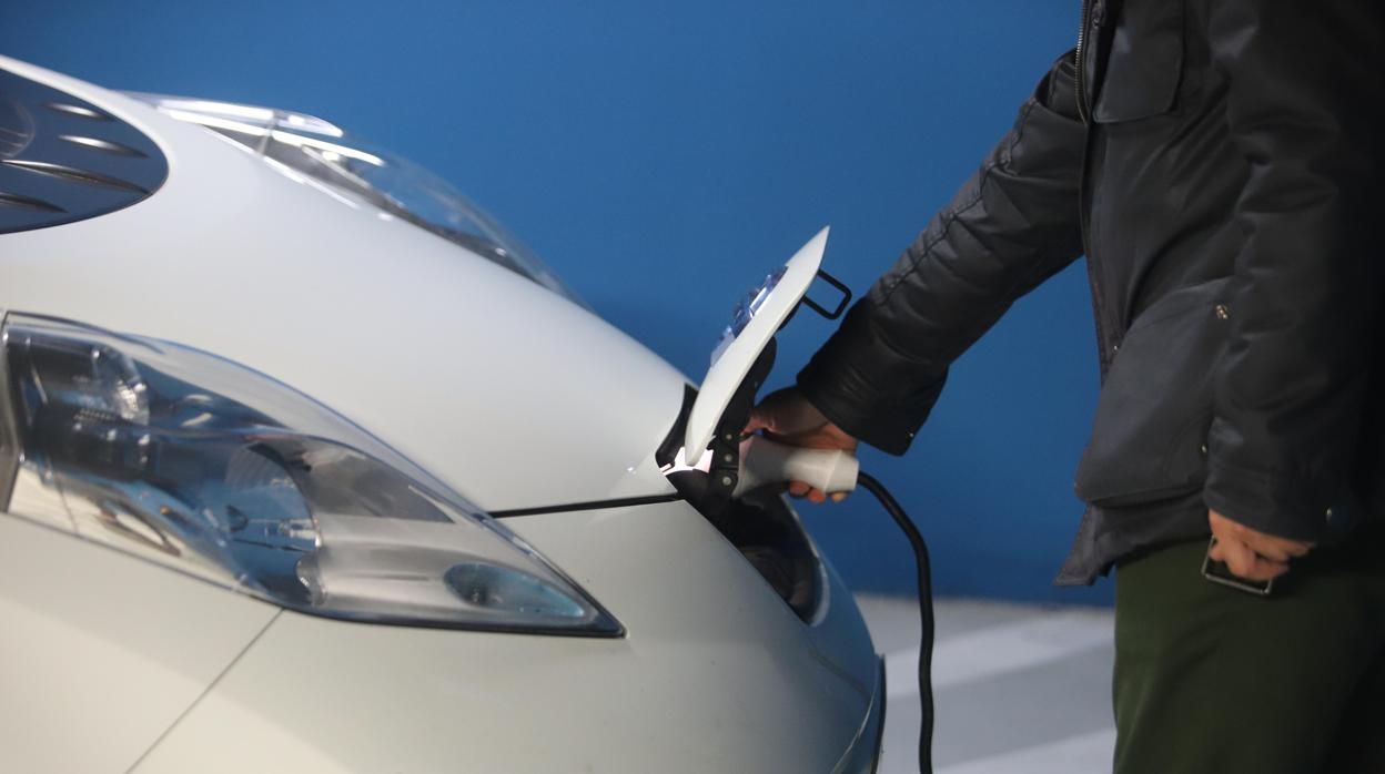 Un hombre recarga su vehículo eléctrico