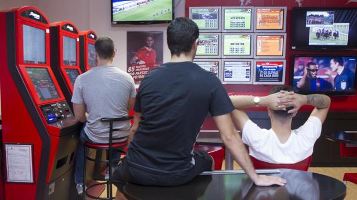 Casa de juegos en la que varios jóvenes obervan las apuestas