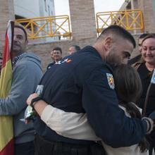 Uno de los agentes abraza a su hija al llegar