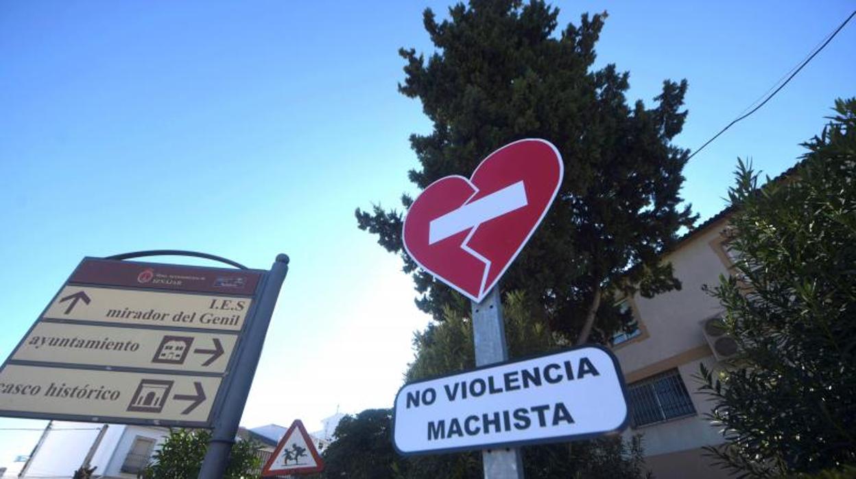 Entrada al pueblo de Iznájar, con un cartel contra la violencia machista